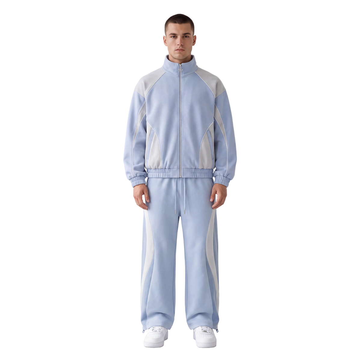 A man modeling a light blue and white tracksuit consisting of a zip-up jacket and matching sweatpants, standing against a plain white studio background.